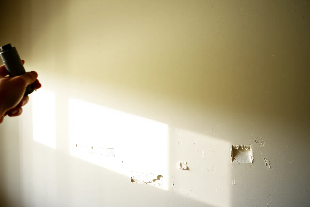 Raking light on old wall showing ghost marks and patches (How to think about former homes interiors)
